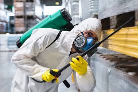Pest control technician treating a residential property exterior