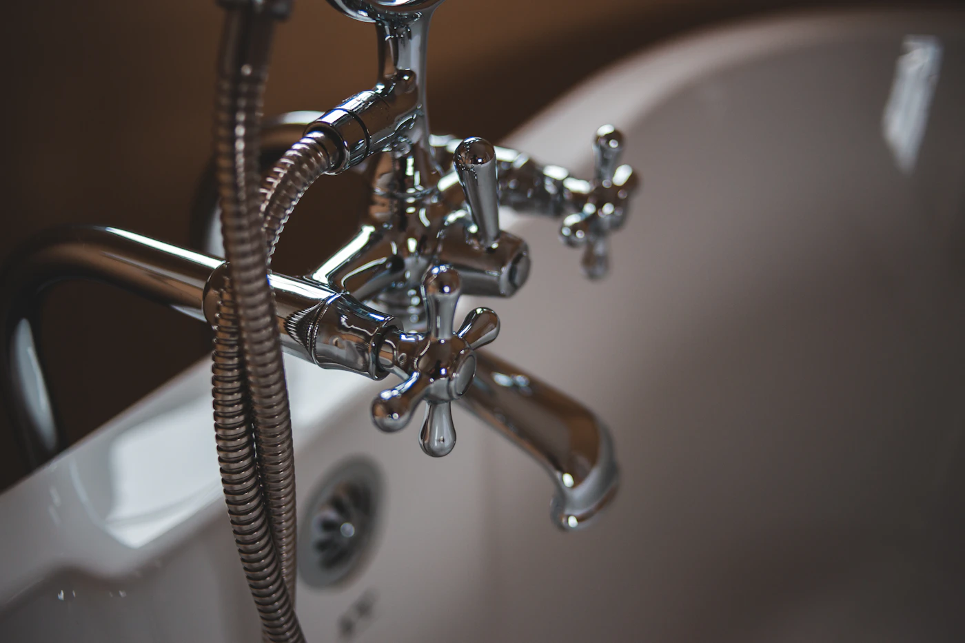 Licensed plumber working under a kitchen sink on a residential plumbing repair